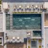Fotografía aérea de las amenidades de un desarrollo residencial: alberca y terrazas.