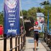 Fotografía deportiva: triatleta en carrera, evento con patrocinadores.