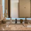 Fotografía inmobiliaria de detalle: baño en mármol para catálogo de propiedad.